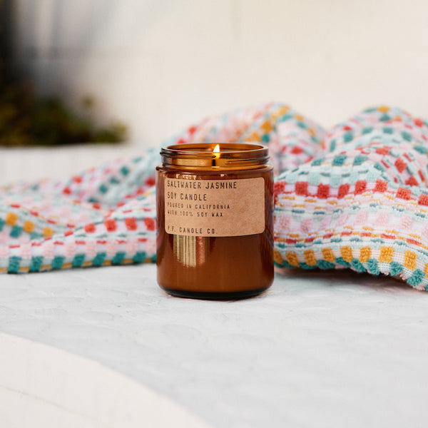 P.F. Candle Co. Saltwater Jasmine Standard Candle - Lifestyle - Coastal mornings blanketed in a gentle marine layer, the warmth of the rising sun, wild white blossoms collecting dew. Ozonic, crisp, clean. Bergamot, sea moss, and sandalwood.