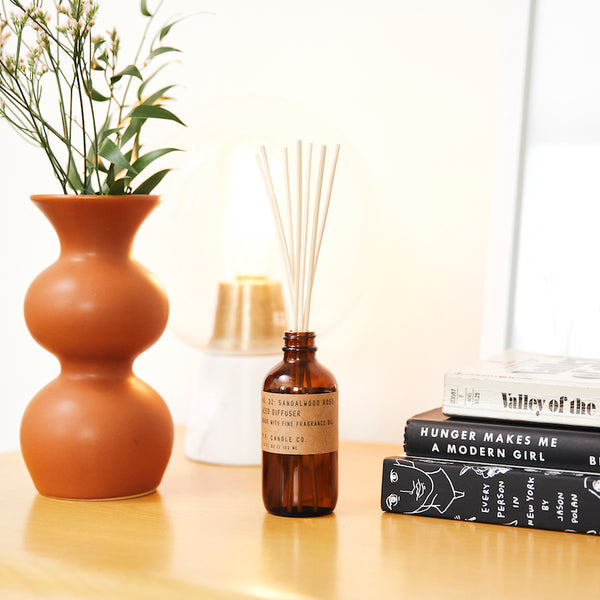 P.F. Candle Co. Sandalwood Rose Reed Diffuser - Lifestyle - New York meets Los Angeles. Cashmere rose, oud, and sandalwood.