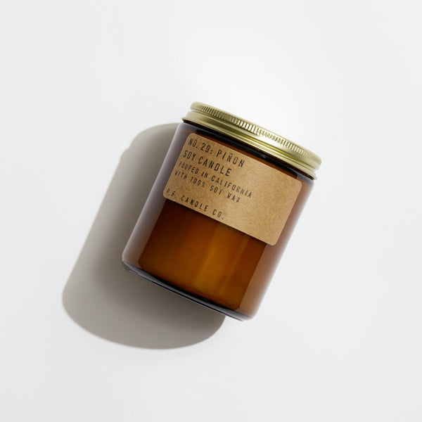 P.F. Candle Co. Piñon Standard Candle - Product - Hand-poured into apothecary inspired amber jars with our signature kraft label and a brass lid.