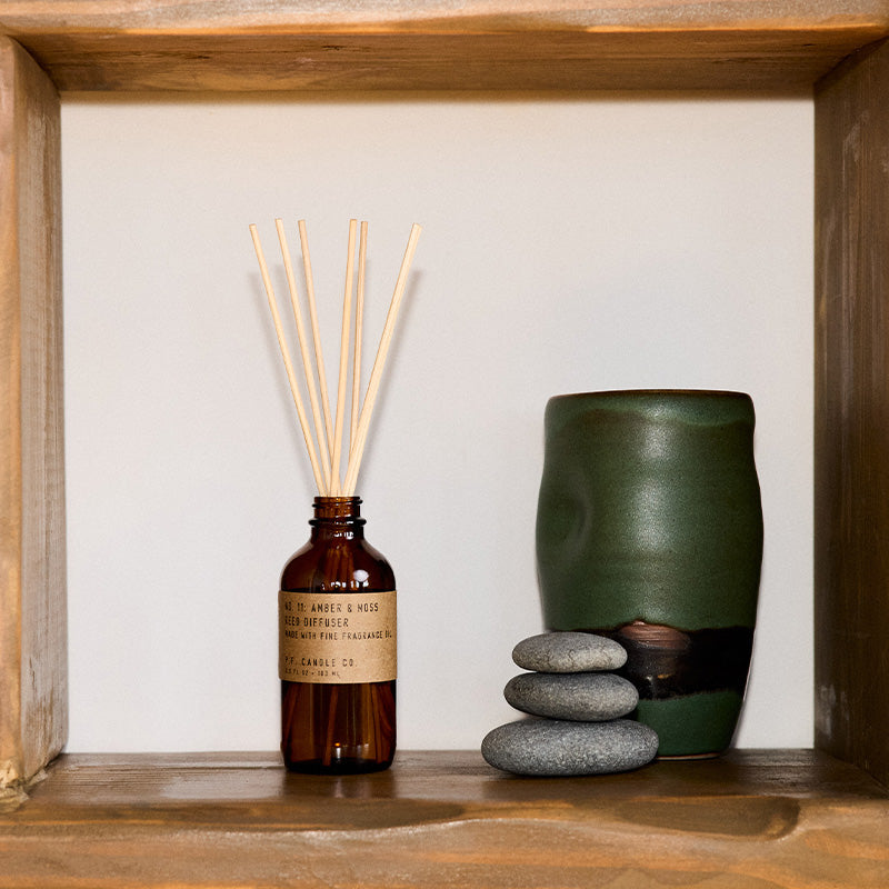 P.F. Candle Co. Amber & Moss Reed Diffuser - Lifestyle - Scent notes of sage, moss, and lavender. Inspired by a weekend in the mountains, sun gleaming through the canopy.