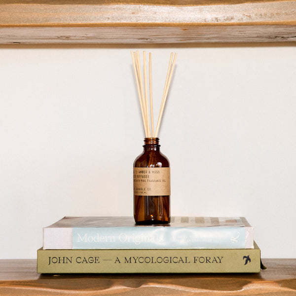 P.F. Candle Co. Amber & Moss Reed Diffuser - Lifestyle - Scent notes of sage, moss, and lavender. Inspired by a weekend in the mountains, sun gleaming through the canopy.