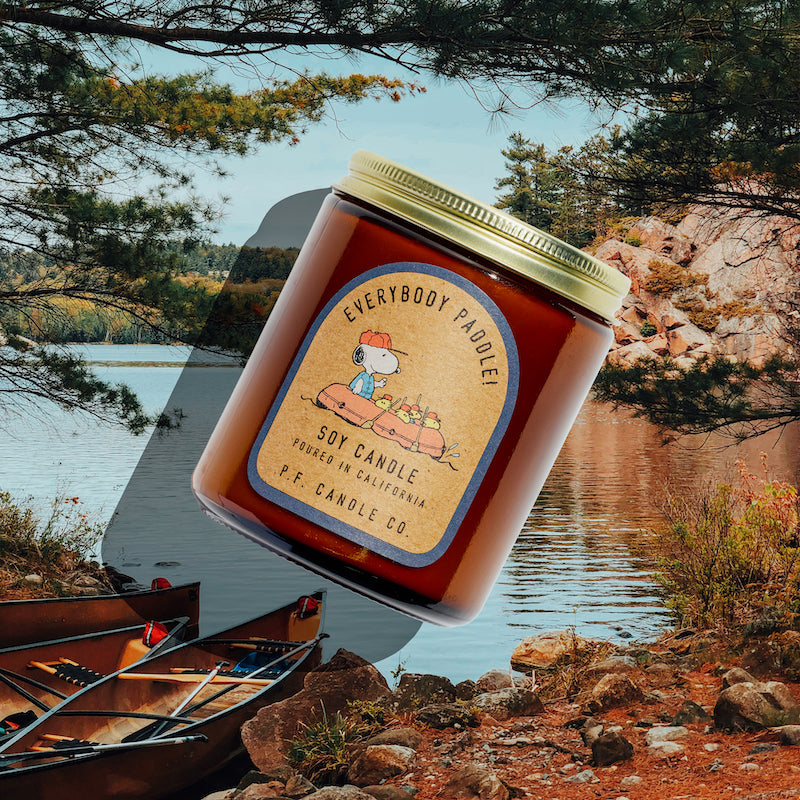 P.F. Candle Co. Everybody Paddle! for Peanuts Standard Candle - Lifestyle - Inspired by afternoon sunlight glimmering on the water and wading through creeks with friends, Everybody Paddle! features aquatic, earthy notes of river moss, bay laurel, and wild fern to brighten your space and bring the outdoors in.