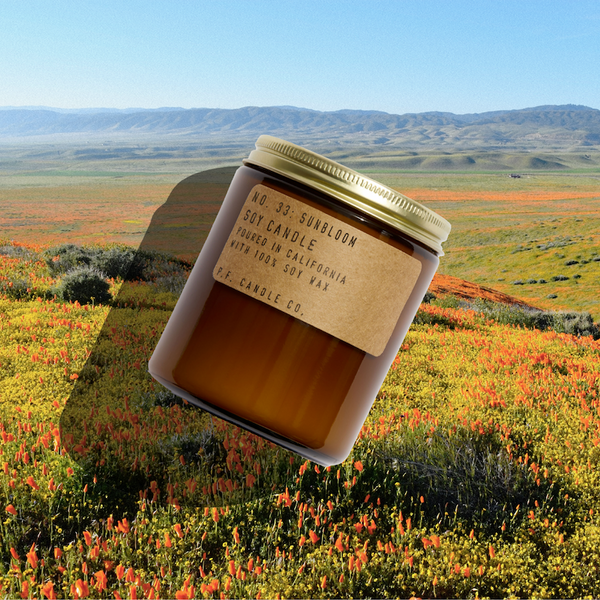 P.F. Candle Co. Sunbloom Standard Candle - Lifestyle - Infinite blankets of kaleidoscopic wildflowers, stopping off the highway to revel in the rainbows, bursting bouquets on full display. Golden-rayed lily, yarrow, and tonka bean.
