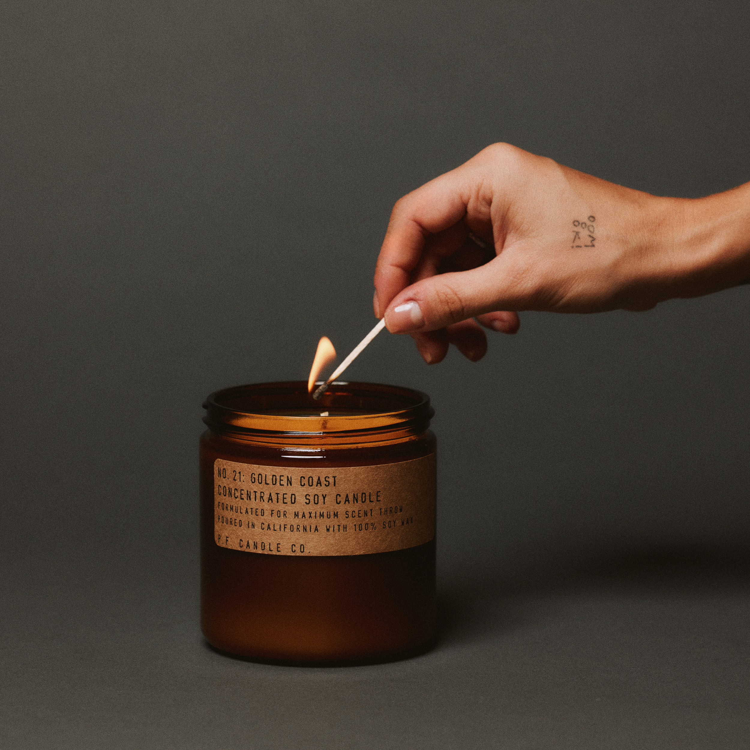 golden coast large concentrated candle being lit up with match in hand 