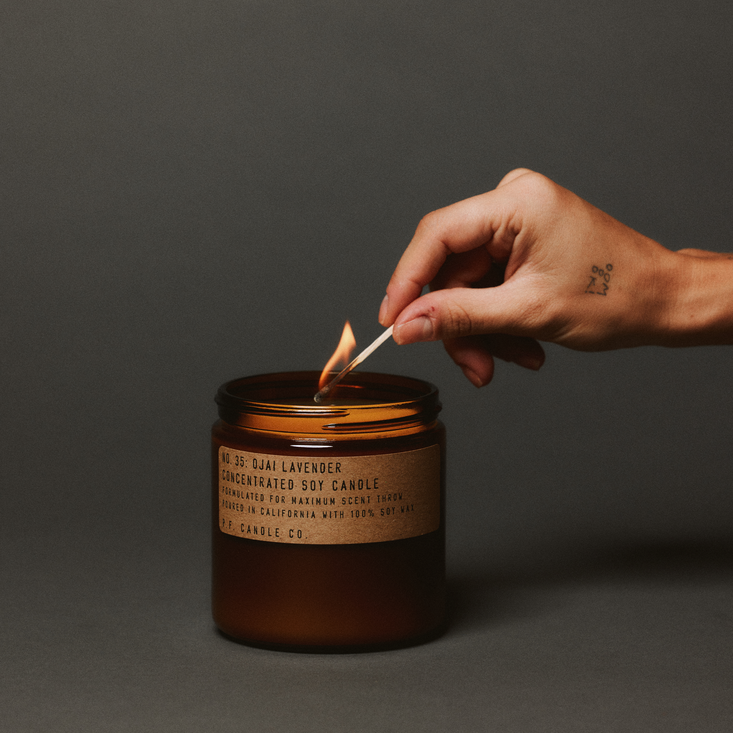ojai lavender large concentrated candle being lit up with match in hand 