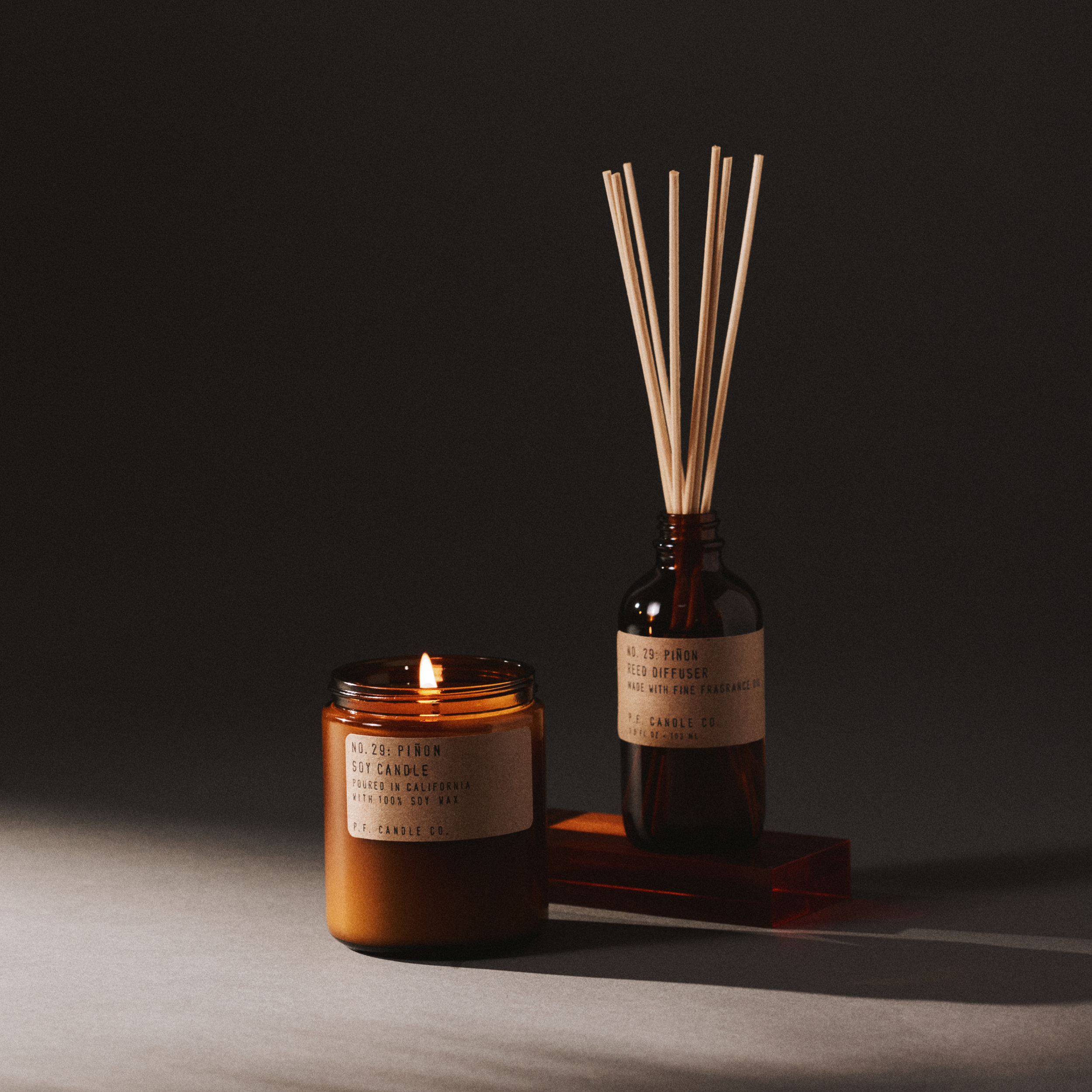 pinon candle and reed diffuser set on a dark background
