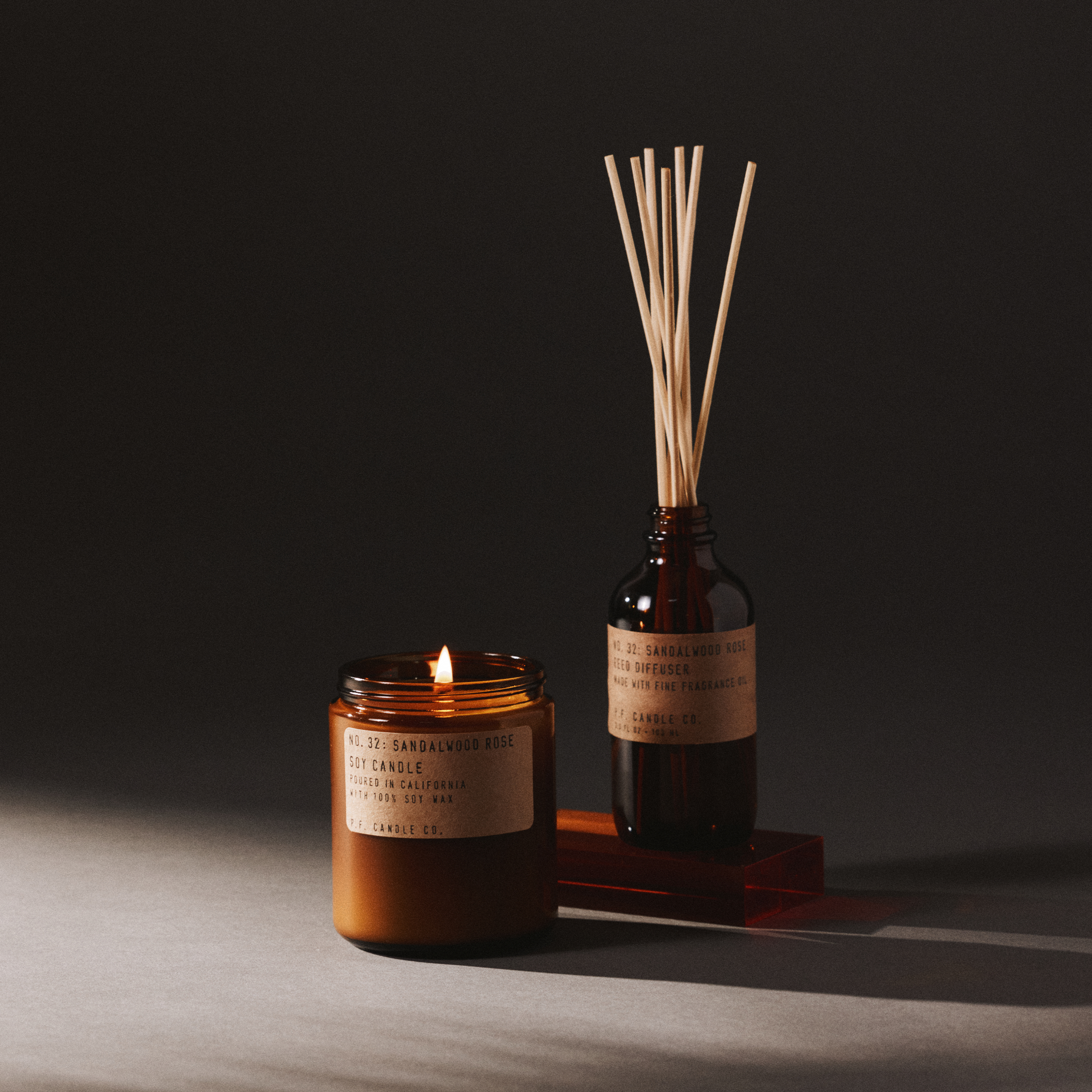 sandalwood rose candle and reed diffuser set on a dark background